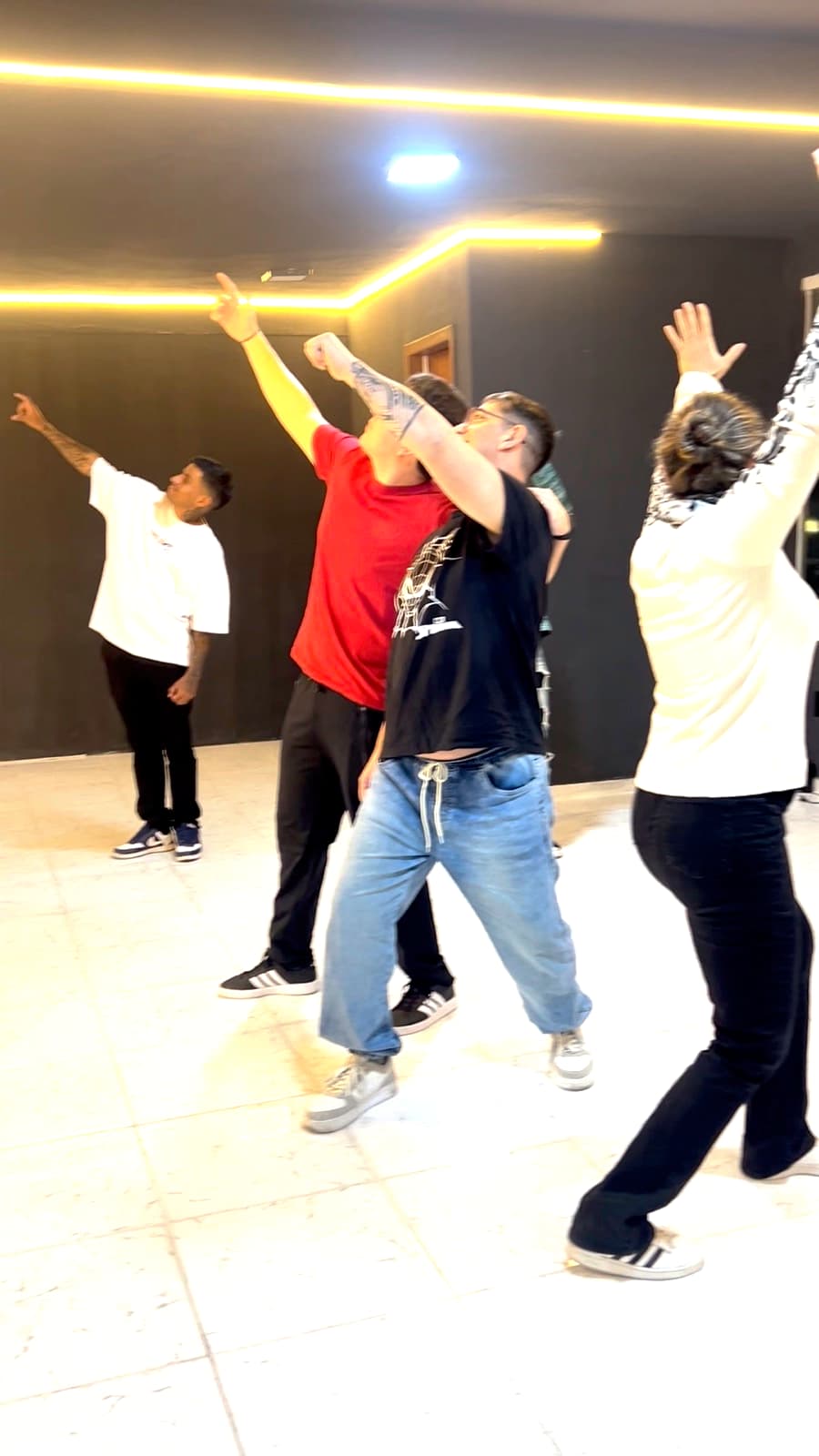 Participantes con los brazos estirados hacia arriba durante la entrada en calor